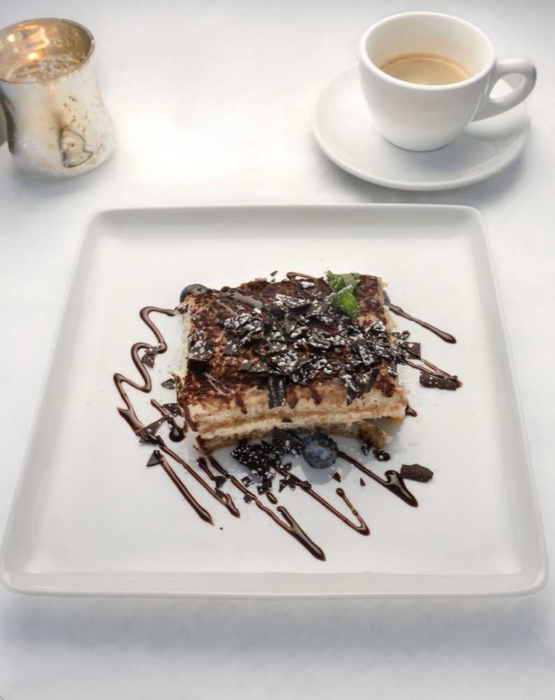 A plated dessert with chocolate sauce and an espresso at Enoteca Adriano