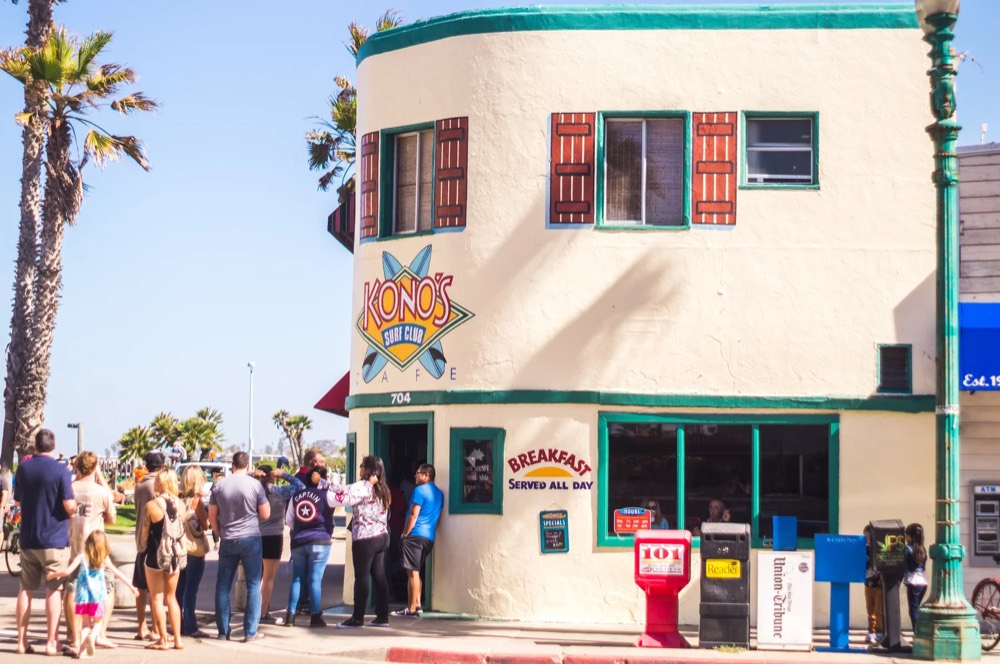 The Kono's Cafe storefront on Ocean Front Walk with a line of people outside