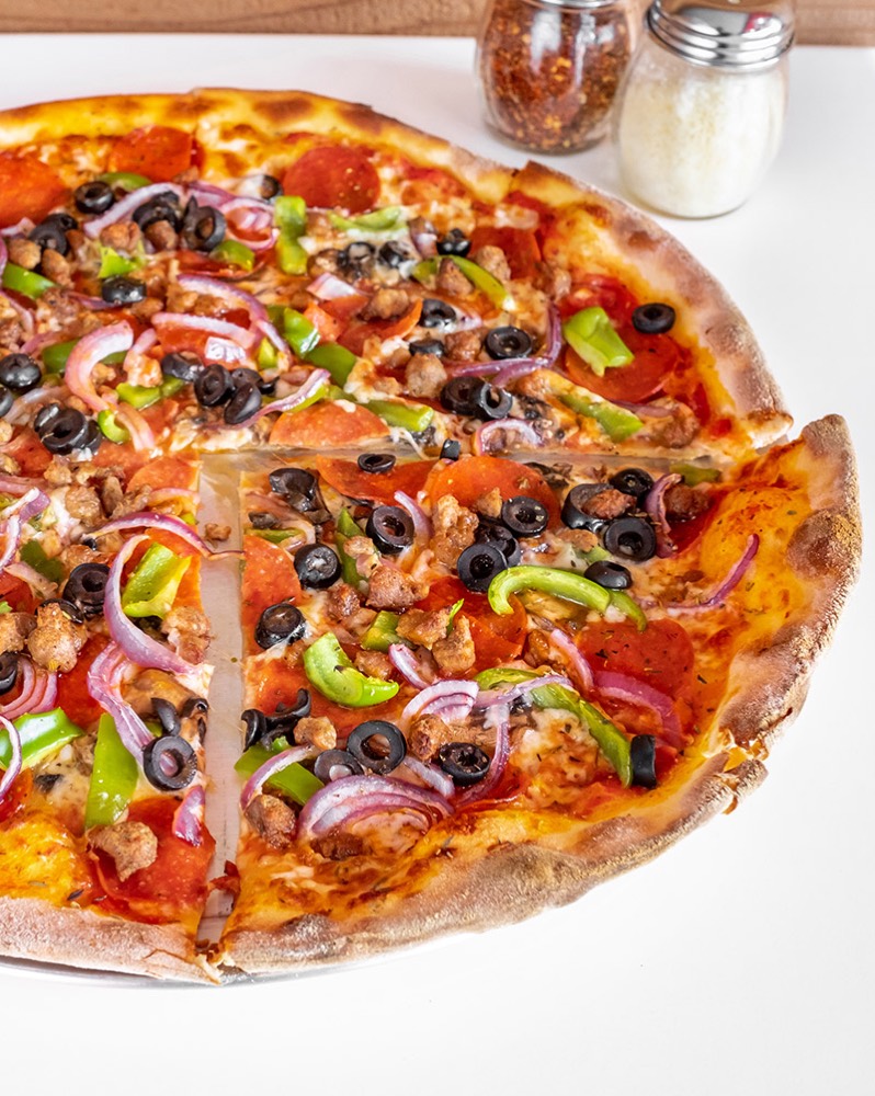 A loaded pizza with pepperoni, peppers and olives from Theo's Hot Pizza